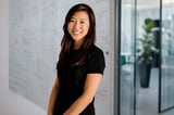 Smiling woman with long dark hair in a modern office setting
